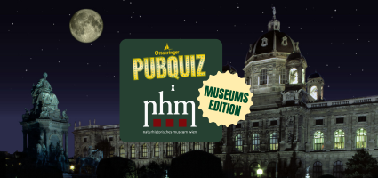 Nachtaufnahme des Naturhistorischen Museum Wiens mit beleuchtetem Turm und Statue der Kaiserin Maria Theresia im Vordergrund, darüber ein Vollmond und ein grünes Schild mit dem Text 'Ottakringer PUBQUIZ x nhm - Museumsedition'.